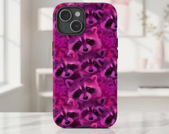 May include: A phone case featuring a repeating pattern of raccoons in shades of pink and purple. The case has a glossy finish and a black camera module. The raccoons have black masks and are set against a floral background.