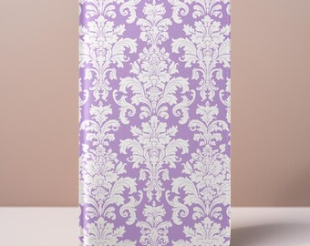 May include: A lavender phone case featuring a white damask pattern. The case has a vertical rectangular shape with rounded corners. The damask design is a repeating floral and scroll motif.