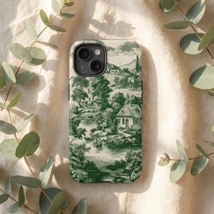 Puede incluir: Una funda de teléfono con un diseño de paisaje campestre en verde y blanco. La funda representa una escena de río con árboles, casas y un barco. La funda tiene un acabado brillante y un recorte para la cámara.