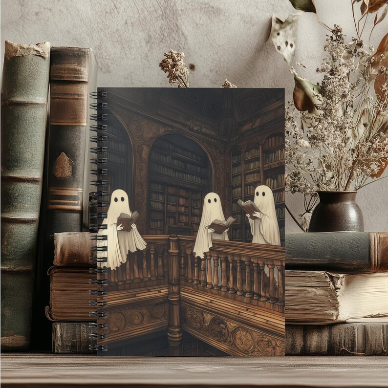 May include: A spiral-bound notebook featuring a spooky illustration of three ghosts reading books in a library. The cover art is set against a backdrop of antique books and a wooden surface, evoking a vintage aesthetic.