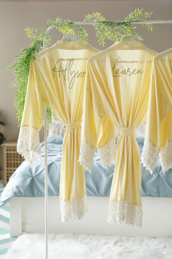 Bridesmaid robes personalized with names, maid of honor, matron of honor, mother of the bride and groom in light yellow.