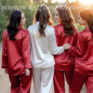 Four women stand outdoors at sunset, wearing coordinated satin pajama sets with long-sleeve shirts. Three wear deep red sets embroidered on the back with gold script reading "Bridesmaid," "Bridesmaid," and "Maid of Honor." The fourth, dressed in white satin, has "Bride" written across the back. The image highlights elegant bridal party sleepwear and showcases personalized embroidery for each role. Text overlay at the top reads: “Pajamas & Long Sleeve Shirt.”
