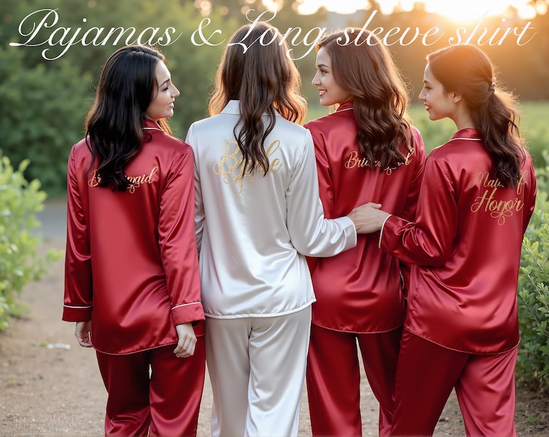 Four women stand outdoors at sunset, wearing coordinated satin pajama sets with long-sleeve shirts. Three wear deep red sets embroidered on the back with gold script reading "Bridesmaid," "Bridesmaid," and "Maid of Honor." The fourth, dressed in white satin, has "Bride" written across the back. The image highlights elegant bridal party sleepwear and showcases personalized embroidery for each role. Text overlay at the top reads: “Pajamas & Long Sleeve Shirt.”