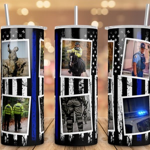 May include: A stainless steel tumbler with a black and white American flag design. The flag is distressed and has a blue line running down the center. The tumbler features images of police officers and a police car.
