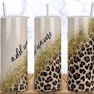 Pode incluir: Um copo de aço inoxidável com um design de glitter dourado e estampa de leopardo. O copo tem um canudo e diz "add name".