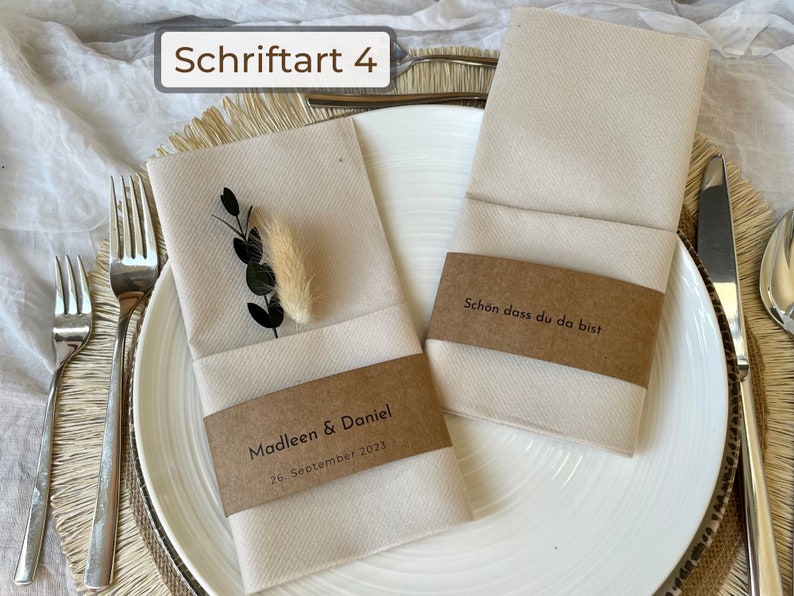 Kraftpapier Banderolen, die um Servietten gebunden sind in einer minimalistischen Schriftart.