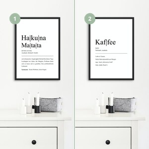 May include: Two black framed prints with white text on a white wall. The print on the left says "Halkulna Maltalta" and the print on the right says "Kaffee".
