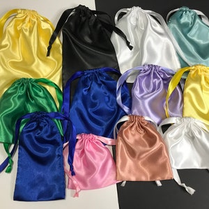May include: Assortment of 11 satin drawstring bags in various colours, including yellow, green, blue, black, white, purple, pink, and brown. The bags are made of soft, silky fabric and have a drawstring closure.