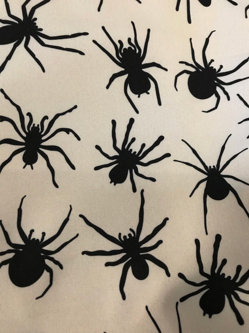 May include: A white fabric with a repeating pattern of black spider silhouettes.