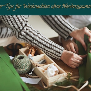 Könnte beinhalten: Zwei Personen verpacken ein grünes Geschenk mit Schnur und Band. Das Geschenk liegt auf einem Holztisch mit einer Holzkiste gefüllt mit Verpackungsmaterial.