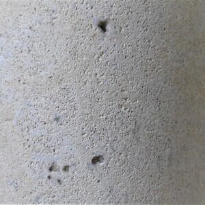K&ouml;nnte beinhalten: Nahaufnahme einer hellbeigen, strukturierten Oberfl&auml;che mit kleinen L&ouml;chern. Die Oberfl&auml;che scheint aus Stein oder Beton zu sein.