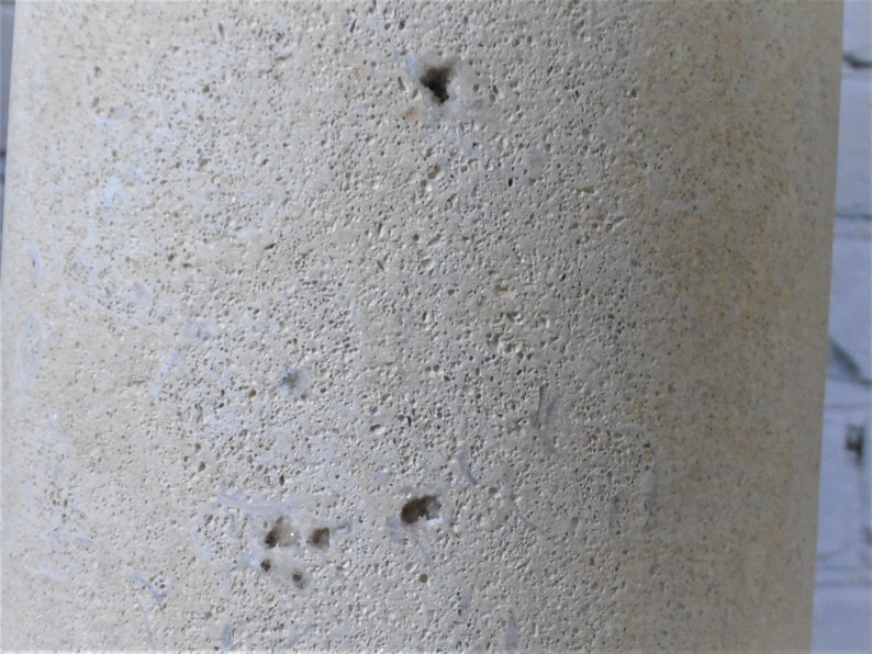 K&ouml;nnte beinhalten: Nahaufnahme einer hellbeigen, strukturierten Oberfl&auml;che mit kleinen L&ouml;chern. Die Oberfl&auml;che scheint aus Stein oder Beton zu sein.