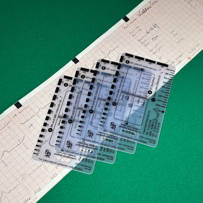 May include: Four clear plastic ECG measurement rulers with black markings. The rulers measure PR, QRS, QT, and ST intervals in seconds. The rulers also measure heart rate in beats per minute. The rulers are labeled "For educational purposes only" and "star-resources.co.uk".