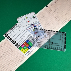 May include: A clear plastic ruler with markings for measuring heart rate, PR, QRS, QT, and ST intervals. The ruler is labeled with "Expected Intervals (s)" and includes measurements in millimeters. The ruler is lying on top of a white card with a diagram of the human body and a chart of common ECG rhythms.