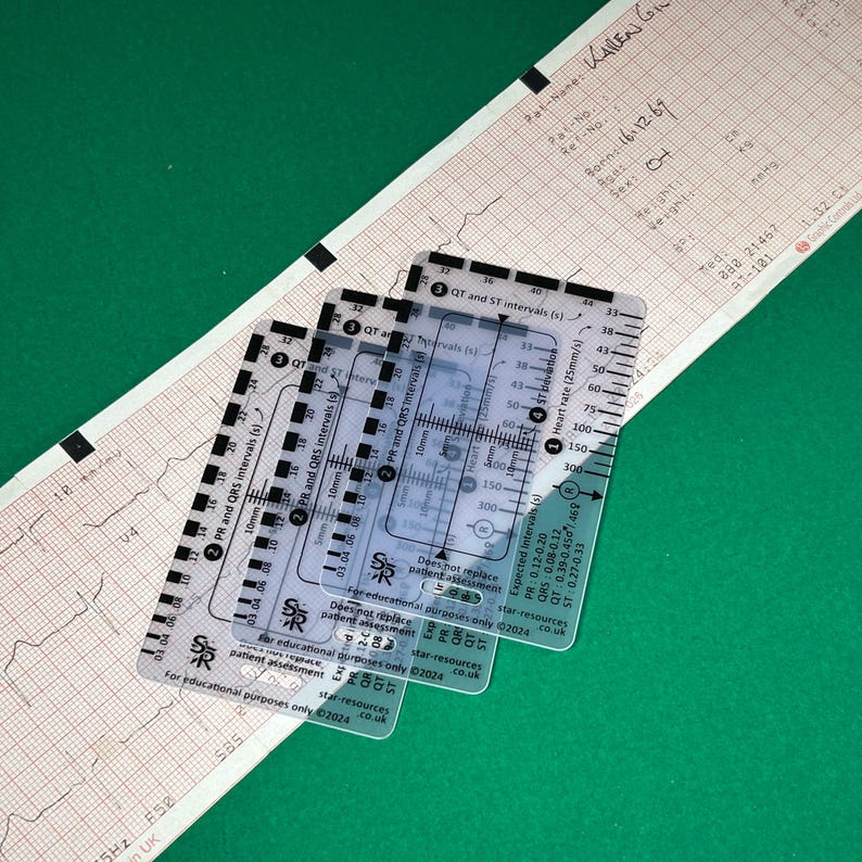 May include: Three clear plastic rulers for measuring heart rate, PR, QRS, QT, and ST intervals on an electrocardiogram (ECG). The rulers are labeled with measurements in seconds and millimeters. The text on the rulers reads "For educational purposes only" and includes a website address.