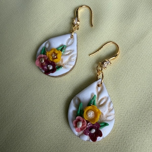 Brincos artesanais de argila polimérica com formato de gota floral | Brincos pendentes brancos em formato de gota | Brincos marcantes com gancho dourado | Joias para presentear na primavera/verão