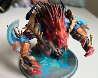 May include: A red and blue 3D printed figurine of a mythical creature with sharp teeth and claws. The creature is standing on a blue and gray circular base.
