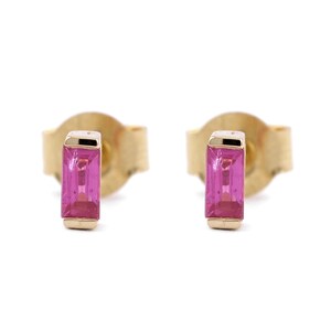 Puede incluir: Un par de pendientes de oro con piedras rectangulares rosas.