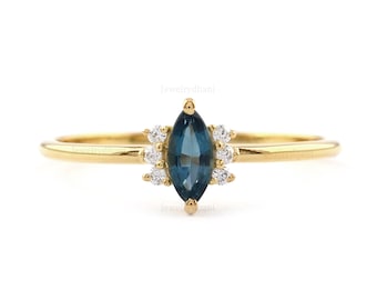 May include: A gold ring with a marquise-shaped blue topaz gemstone surrounded by a halo of small round diamonds.