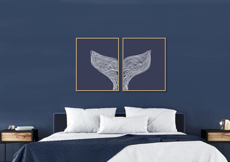 May include: Two framed prints of a white line drawing of a whale tail on a dark blue background.