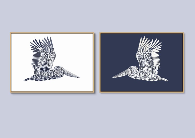 May include: Two framed prints of a stylized pelican in flight, one with a white background and the other with a dark blue background. The pelican is made up of small, repeating shapes.
