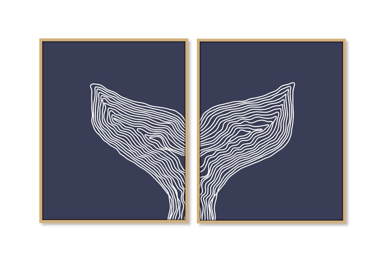 May include: A set of two abstract art prints featuring a white line drawing of a whale tail on a navy blue background. The prints are framed in a light wood frame.