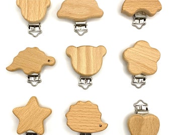 May include: Nine wooden baby teethers with metal clips. The teethers are shaped like a bear, cloud, car, dinosaur, star, hedgehog, heart, and two different bears.