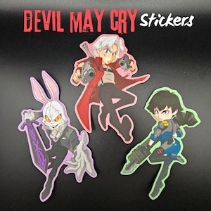 May include: A selection of "Devil May Cry" stickers. The stickers feature three different character designs. One shows a character with white hair and a red coat holding two guns. Another depicts a character with a rabbit mask. The third shows a character with a gun.
