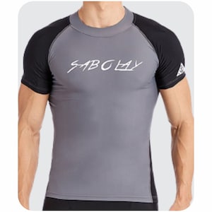 May include: A gray and black rash guard with a white logo that says "SABCLAY".