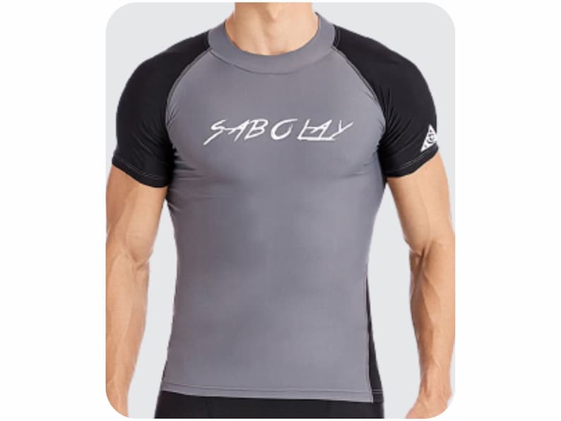 May include: A gray and black rash guard with a white logo that says "SABCLAY".