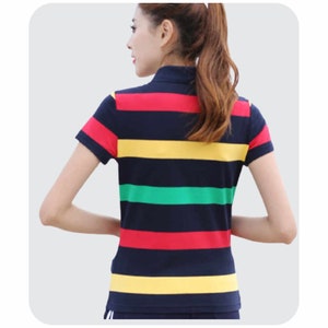 May include: A striped short-sleeved shirt with a collar. The shirt has horizontal stripes in navy blue, yellow, red, and green.