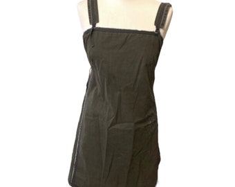 May include: A sleeveless, dark green dress with thin white straps and a straight, slightly A-line silhouette.