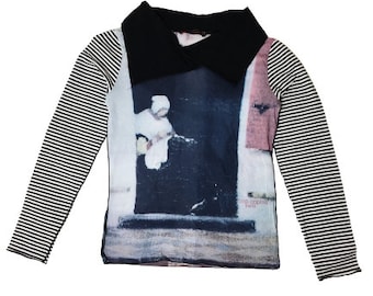 May include: Black and white striped long-sleeve shirt with a black collar and a printed image of a person in a white dress. The image has the text "Comptoir des Cotonniers Paris" printed on the bottom right corner.