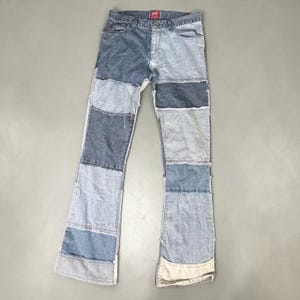 Peut inclure: Jean patchwork en denim dans les tons de bleu et de gris. Le jean présente un motif patchwork avec différents panneaux de denim cousus ensemble. Le jean a une conception classique à cinq poches et une coupe droite.