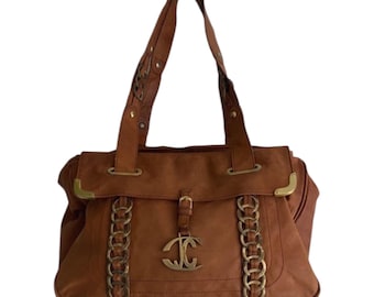 May include: A brown leather handbag with gold-tone chain detailing and a flap closure. The bag has a double handle and a gold-tone logo charm. The bag is a medium size and has a structured shape.