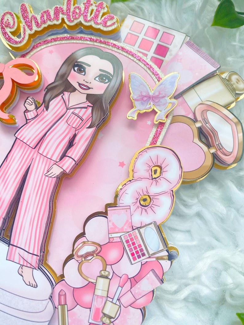 Personalized makeup-themed cake topper featuring a girl in pink striped pajamas surrounded by beauty and spa accessories including makeup brushes, lipstick, blusher, eyeshadow, skincare items, and a pink bow. The topper is decorated in pink glitter card and gold mirror  with the name and age of the birthday girl, making it perfect for a glam birthday, spa party, or makeup-themed celebration.
