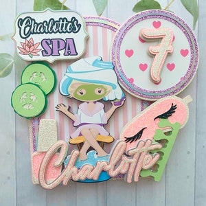 Puede incluir: Adorno para tarta con tem&aacute;tica de spa con el texto "Charlotte's SPA" y una ni&ntilde;a de dibujos animados con mascarilla. Incluye rodajas de pepino, el n&uacute;mero 7 y el nombre "Charlotte". El dise&ntilde;o utiliza acentos rosas, blancos, verdes y brillantes.