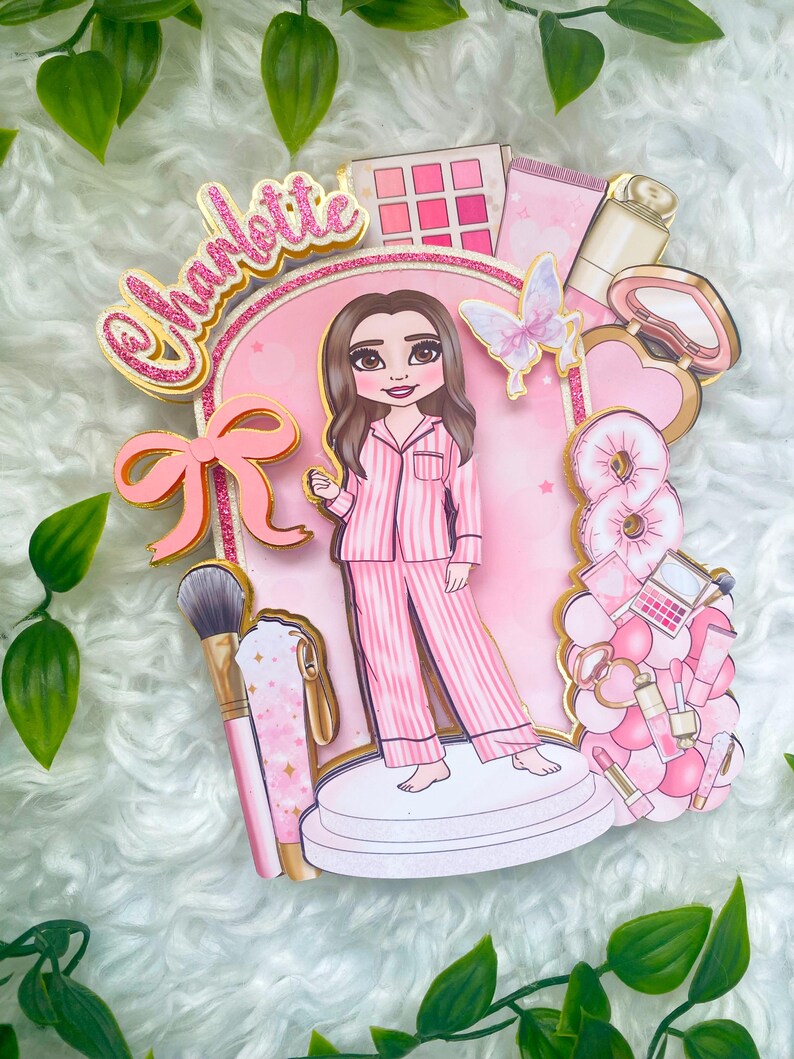 Personalized makeup-themed cake topper featuring a girl in pink striped pajamas surrounded by beauty and spa accessories including makeup brushes, lipstick, blusher, eyeshadow, skincare items, and a pink bow. The topper is decorated in pink glitter card and gold mirror  with the name and age of the birthday girl, making it perfect for a glam birthday, spa party, or makeup-themed celebration.