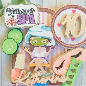 Puede incluir: Un adorno para pastel con tem&aacute;tica de spa que presenta a una ni&ntilde;a de dibujos animados con una mascarilla, pepinos, esmalte de u&ntilde;as y una m&aacute;scara para dormir. El adorno incluye el texto "Katherine's SPA" y el n&uacute;mero 10, con detalles en rosa y dorado.