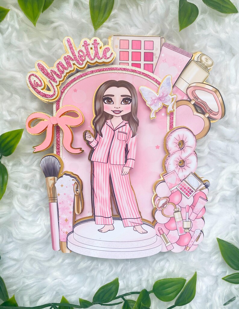Personalized makeup-themed cake topper featuring a girl in pink striped pajamas surrounded by beauty and spa accessories including makeup brushes, lipstick, blusher, eyeshadow, skincare items, and a pink bow. The topper is decorated in pink glitter card and gold mirror  with the name and age of the birthday girl, making it perfect for a glam birthday, spa party, or makeup-themed celebration.