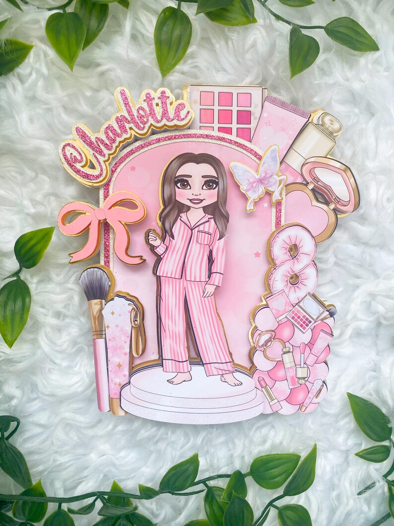 Personalized makeup-themed cake topper featuring a girl in pink striped pajamas surrounded by beauty and spa accessories including makeup brushes, lipstick, blusher, eyeshadow, skincare items, and a pink bow. The topper is decorated in pink glitter card and gold mirror  with the name and age of the birthday girl, making it perfect for a glam birthday, spa party, or makeup-themed celebration.