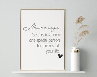 May include: A white framed print with the text "Marriage: Getting to annoy one special person for the rest of your life" and a small black heart.