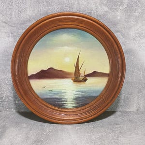 peinture à l'huile vintage de paysage marin. Un petit tableau d'un artiste ukrainien dans des tons bleus et dorés, représentant la mer, le bateau, le soleil, le soir.