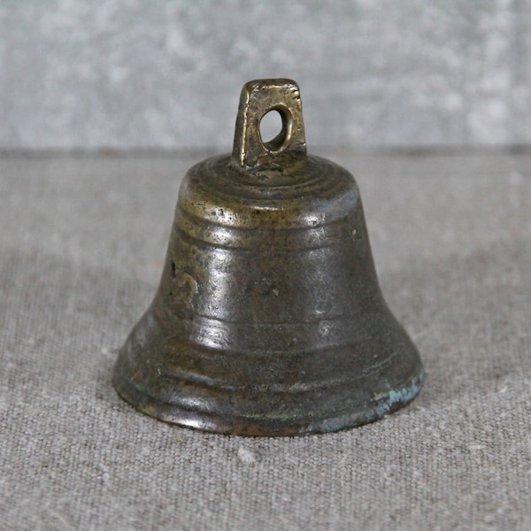 Vintage Eisen kleine Glocke. Eine kleine Glocke mit einer Aufschrift. Sammlerstück Alte historische Sache.