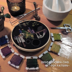 May include: A cross-stitch embroidery hoop with a black background and a colourful design featuring kitchen utensils and text. The image includes spools of thread, scissors, and other craft supplies. The text "DIGITAL DOWNLOAD ~ PDF PATTERN~" is visible.