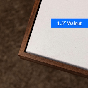 May include: A corner view of a canvas print with a 1.5-inch walnut frame. The canvas is white, and the frame is a dark brown color. A blue rectangle with the text "1.5" Walnut" is visible.