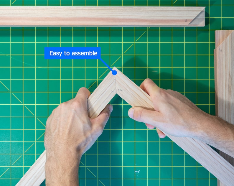 May include: A person assembling a wooden frame. The frame is made of light wood and has a green background. The text "Easy to assemble" is written on a blue banner.