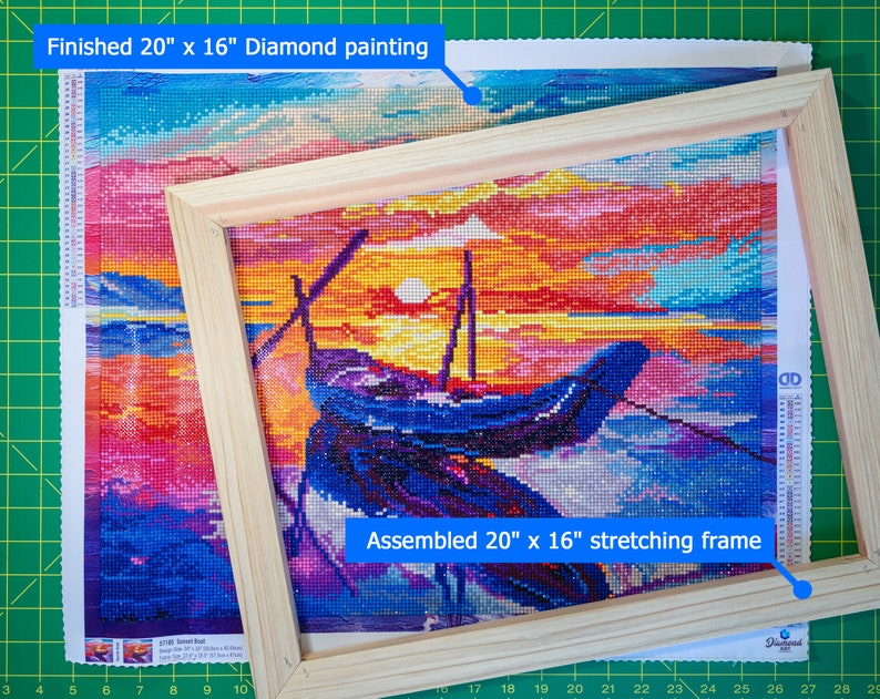 May include: A finished 20" x 16" diamond painting of a sunset seascape with a boat in the foreground. The painting is mounted in a wooden stretching frame.