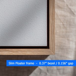 May include: Close-up of a wooden frame with a white canvas inside. The frame is a slim floater frame with a 0.37" bezel and a 0.156" gap.