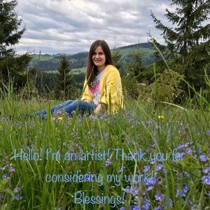 Op de afbeelding: Een vrouw in een geel jack en een wit shirt met een roze ontwerp zit in een veld met blauwe bloemen. De achtergrond is een groen bos en een bewolkte lucht. De tekst "Hello! I'm an artist! Thank you for considering my work! Blessings!" staat in blauwe tekst op de afbeelding.
